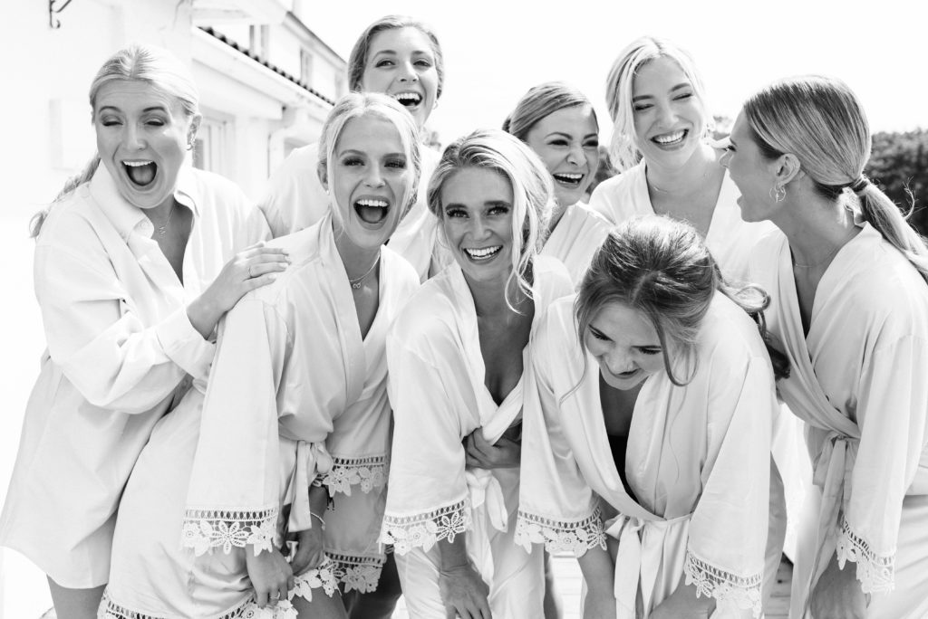 Bridesmaids laughing with robes on.