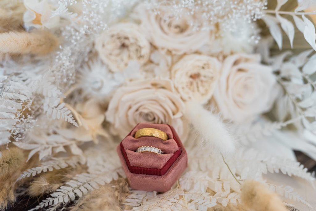 Detail image of wedding rings and flowers.