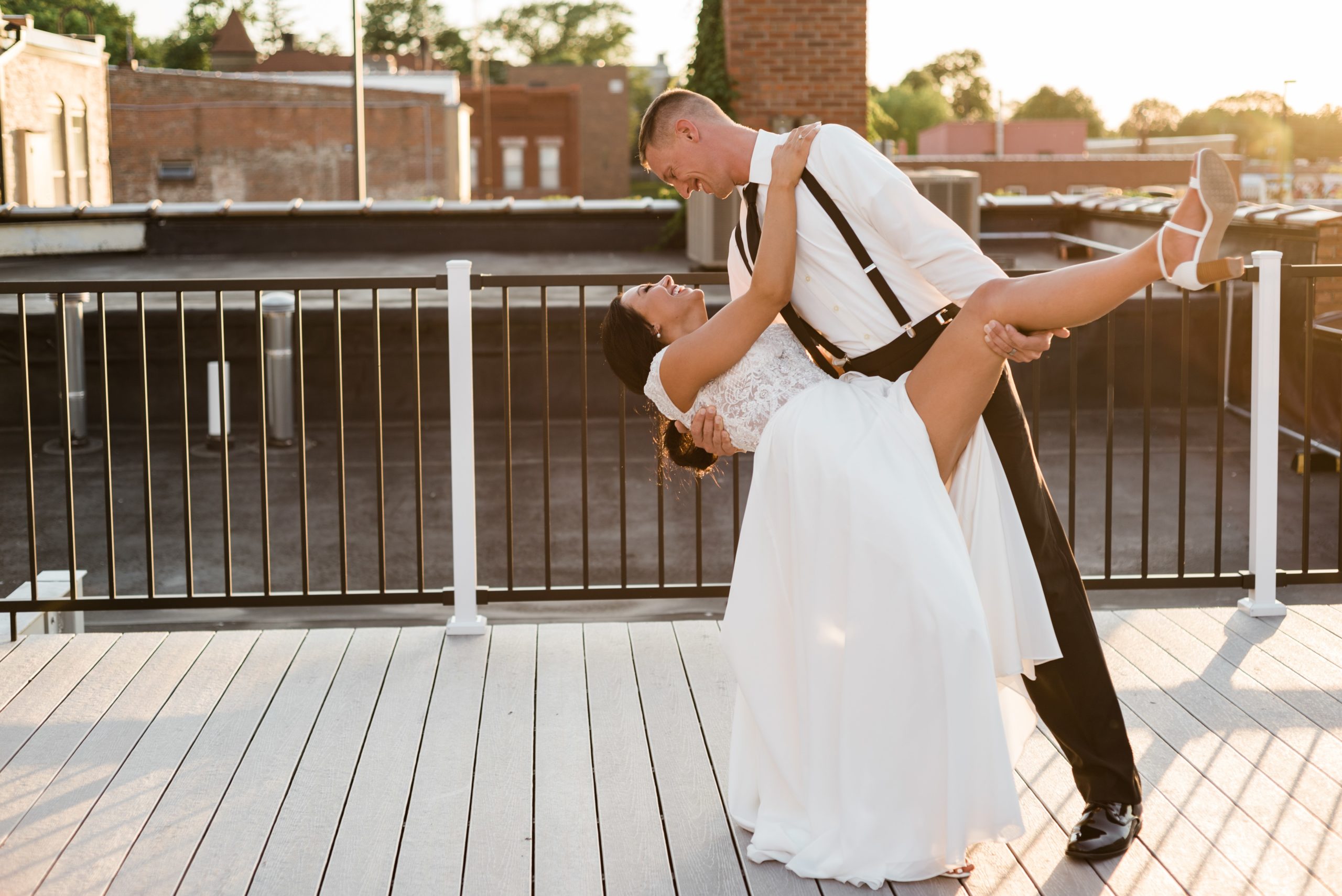 Groom dipping bride on a rooftop.