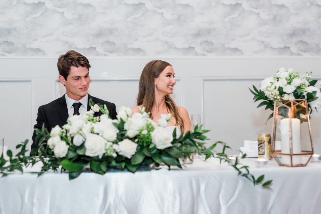 Bride and groom smiling at the head table, Metropolitan Ballroom.
