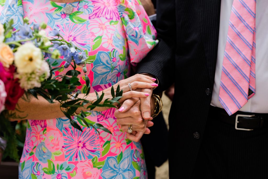 Family members holding hands wearing wedding attire.