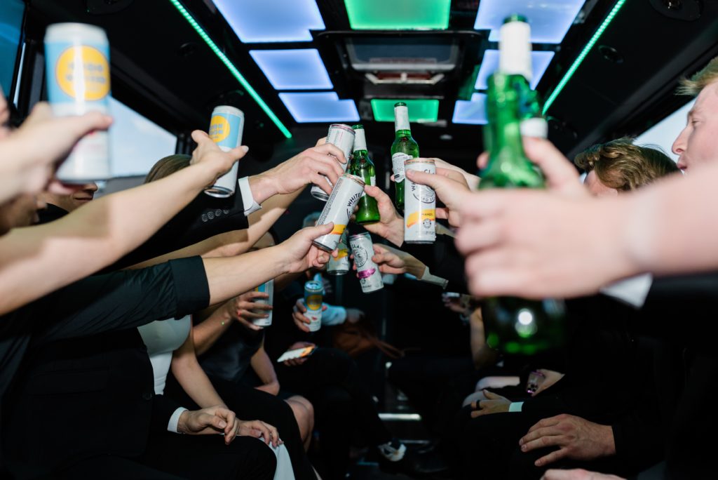 Bottles of beer and cans of White Claws cheering on the party bus.