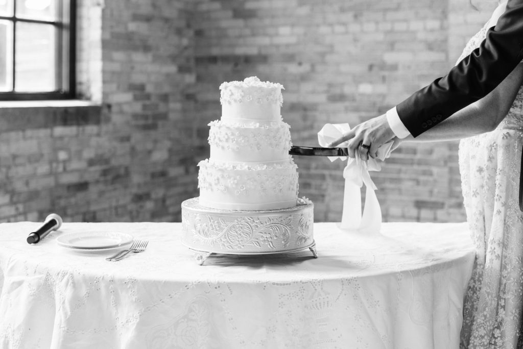 A detail of the bride and groom cutting the cake.