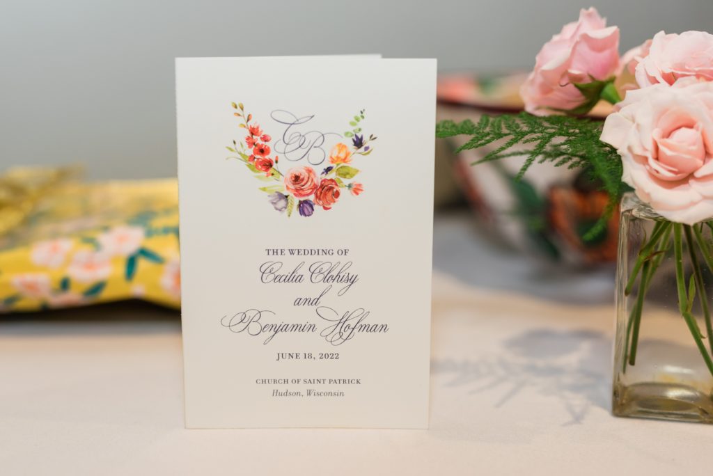 Wedding card on display next to flowers.