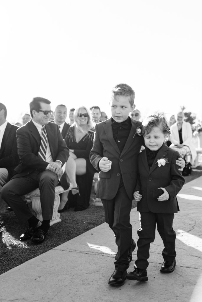 Ring bearers walking down the aisle and the younger one tearing up.