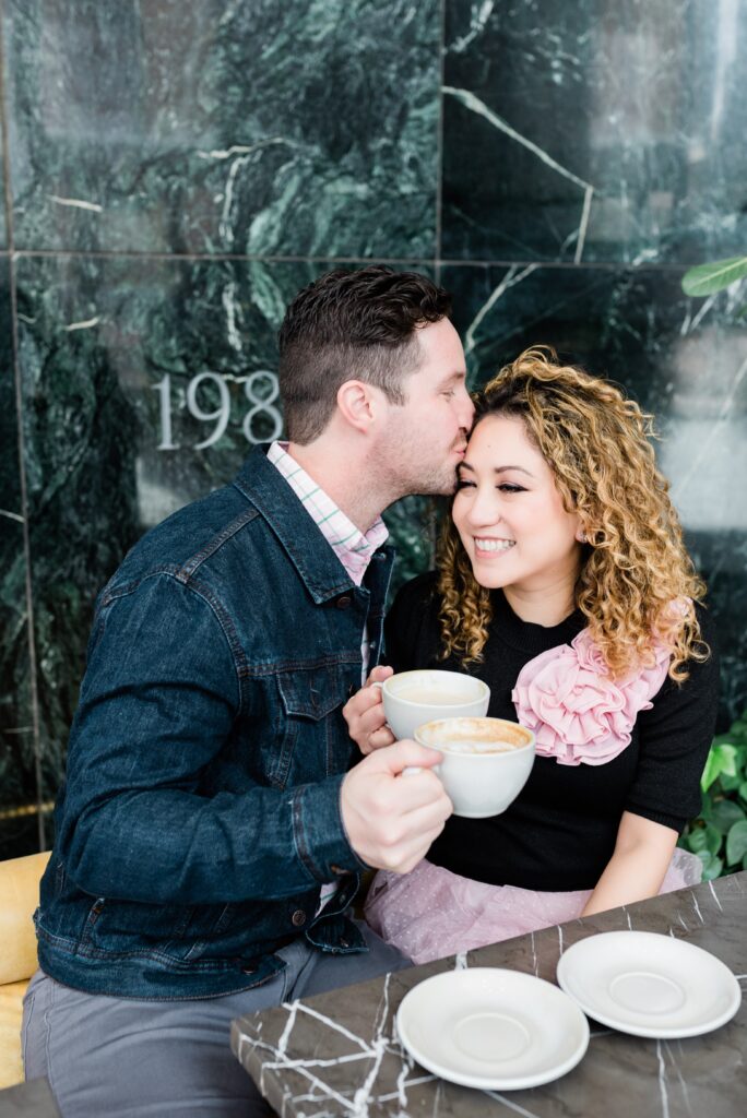 Man kissing woman smile while holding coffee at Cafe Ceres.