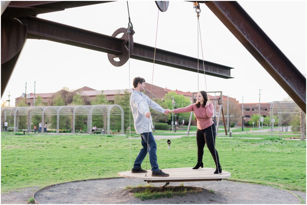 Couple standing on a flat swing at the Minneapolis Sculpture Garden.
