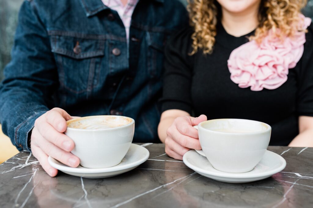 A closeup of a couple holding their cups of coffee.