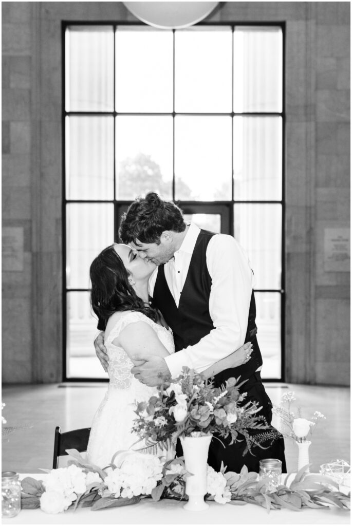 Bride and groom kiss at the head table. 