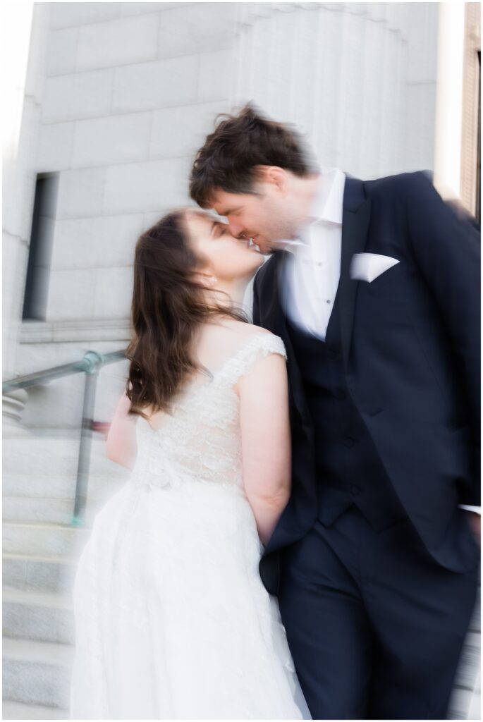 Blurry photo of bride and groom kissing up close. 