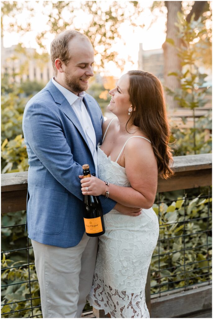 Couple hugging and holding champagne bottle.