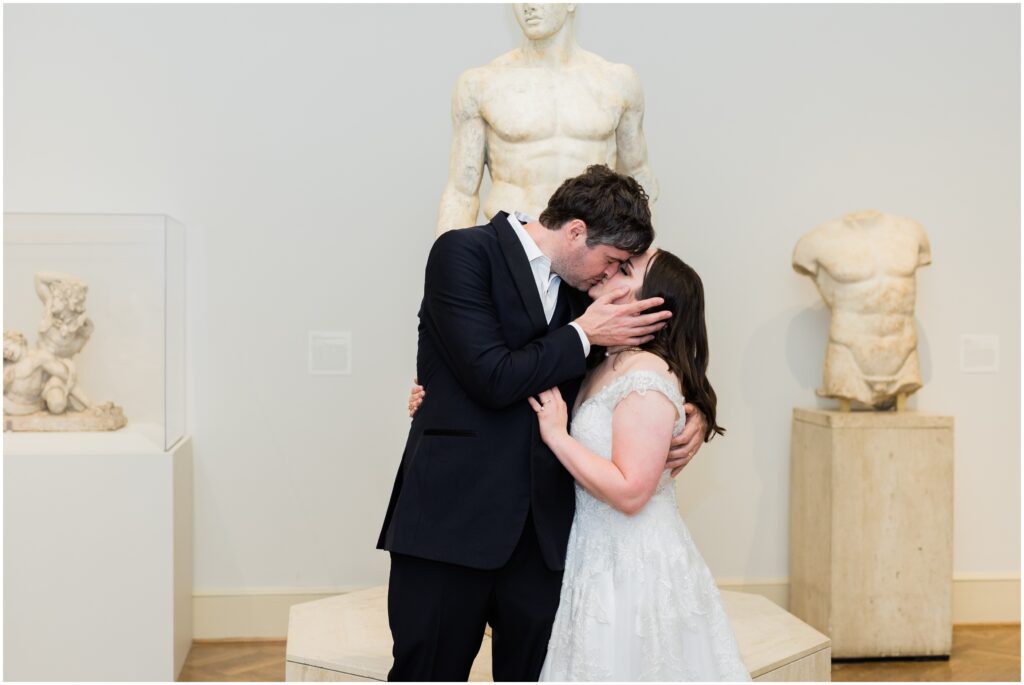Bride and groom kiss in the art galleries of Minneapolis Institute of Art
