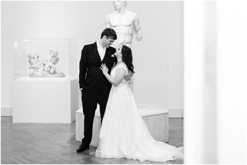 Bride and groom look at each other in an art gallery at the Minneapolis Institute of Art.