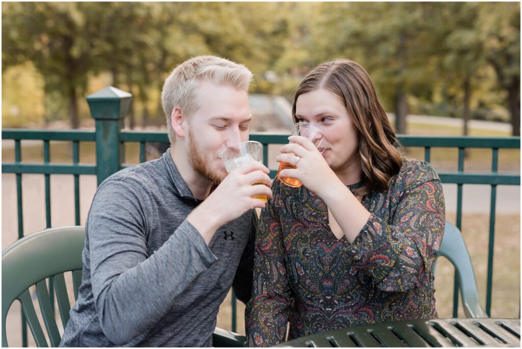 Girlfriend and boyfriend smile while drinking beer at Minnehaha Falls.