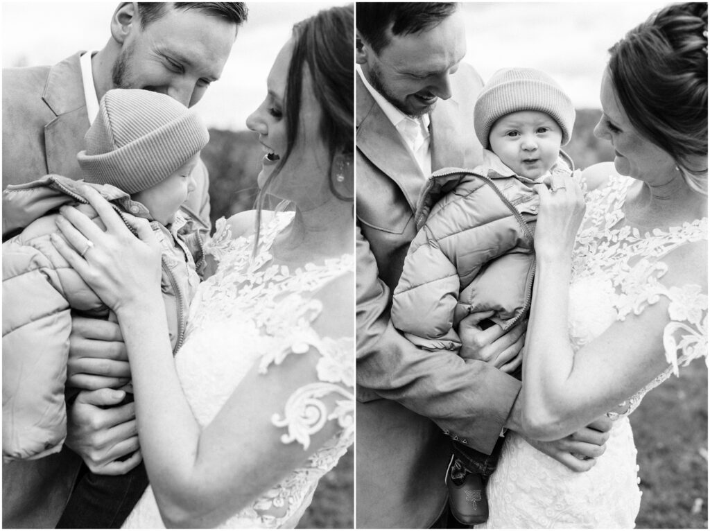 Bride and groom hugging and holding their son on the day of their wedding.
