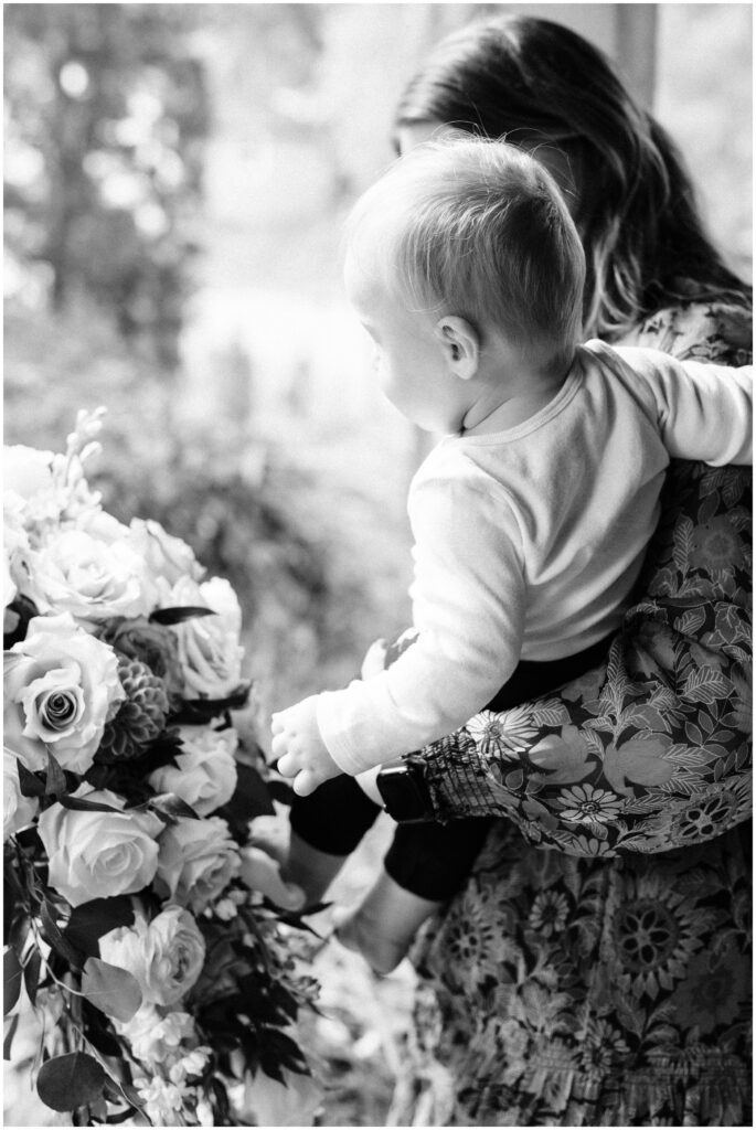 Baby looking at the bride's flowers at James Mulvey Inn.