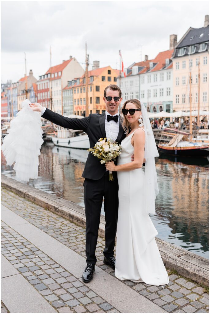 Bride and groom pose with sunglasses and jacket at Nyhavn during Copenhagen Elopement.