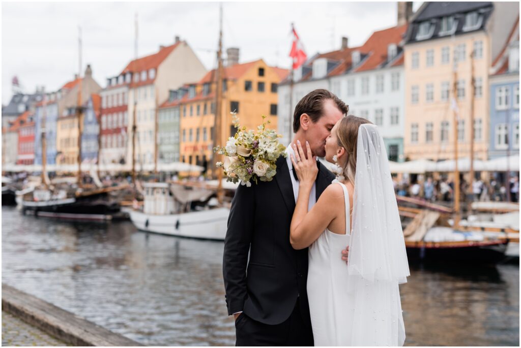 Bride and groom kiss at Nyhavn, Copenhagen.