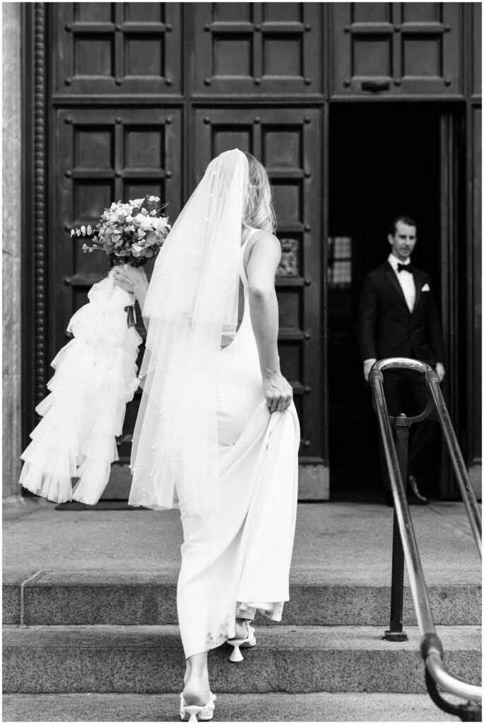 Bride and groom walk up the stairs of the City Hall in Copenhagen, Denmark. 