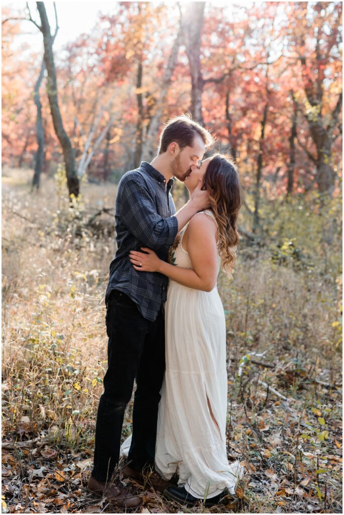 Engagement photos of a couple kissing in the woods at Lebanon Hills.