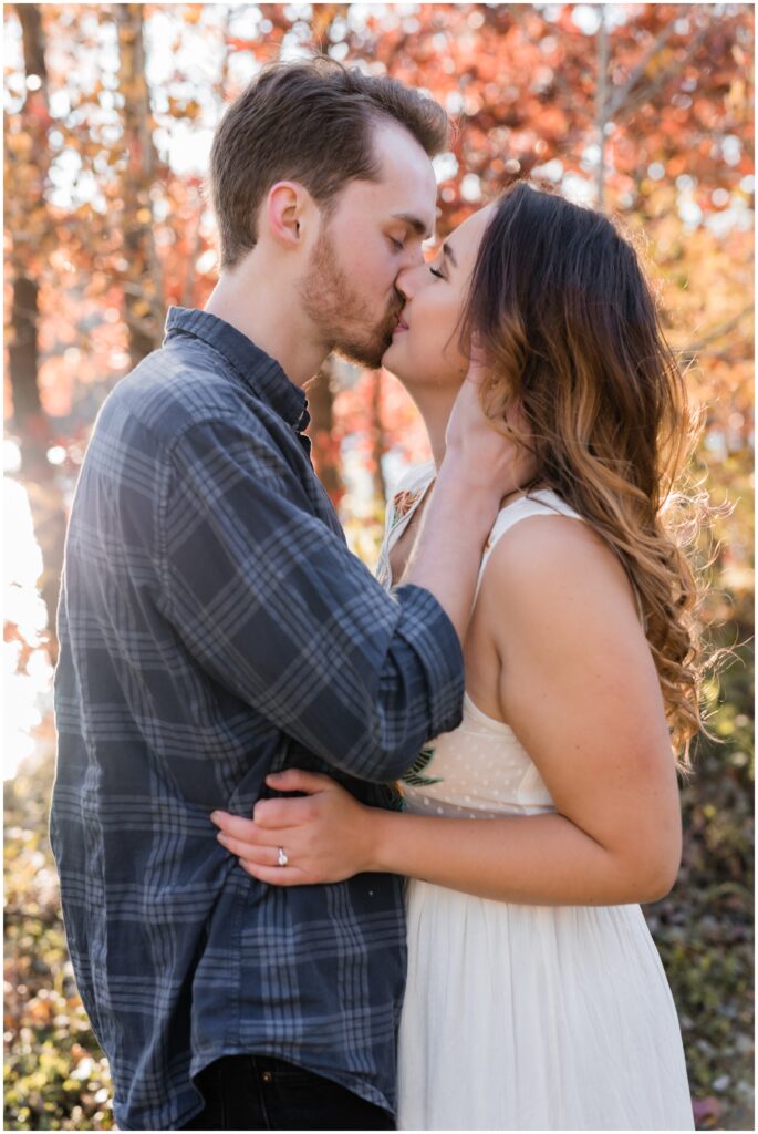 Engagement photos at Lebanon Hills of a couple kissing during the fall time. 