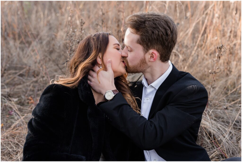 An engaged couple kiss in the field at Lebanon Hills, Eagan, MN.