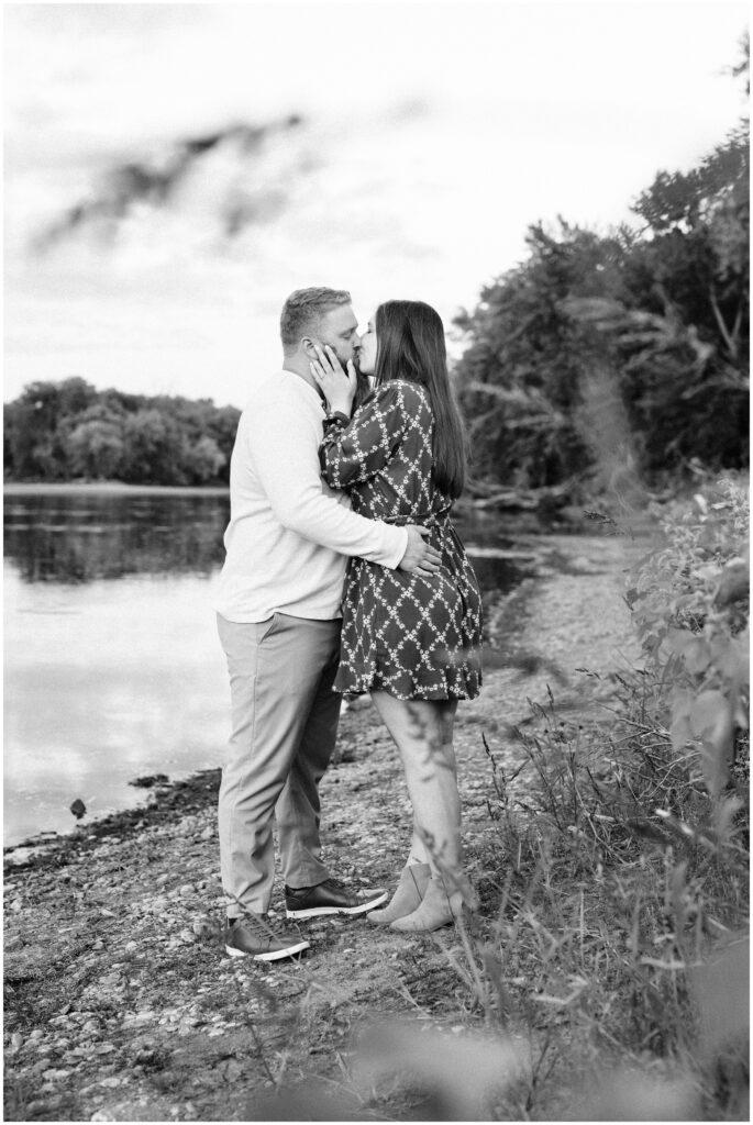 Couple kiss while holding each other at Otsego County Park. 