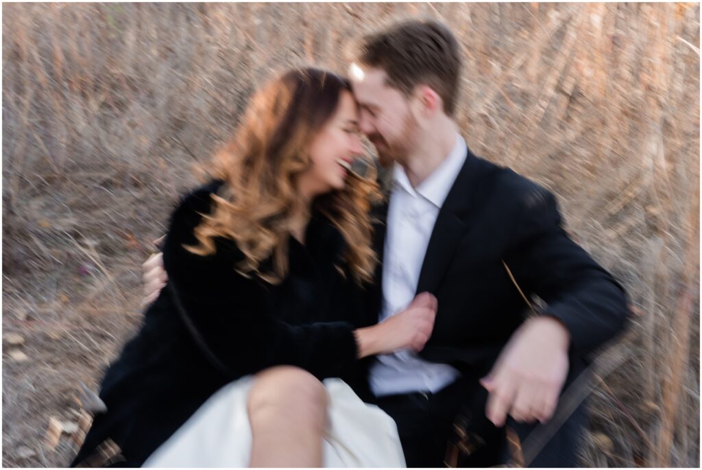 Blurry photo of a couple sitting on the ground in a field. 
