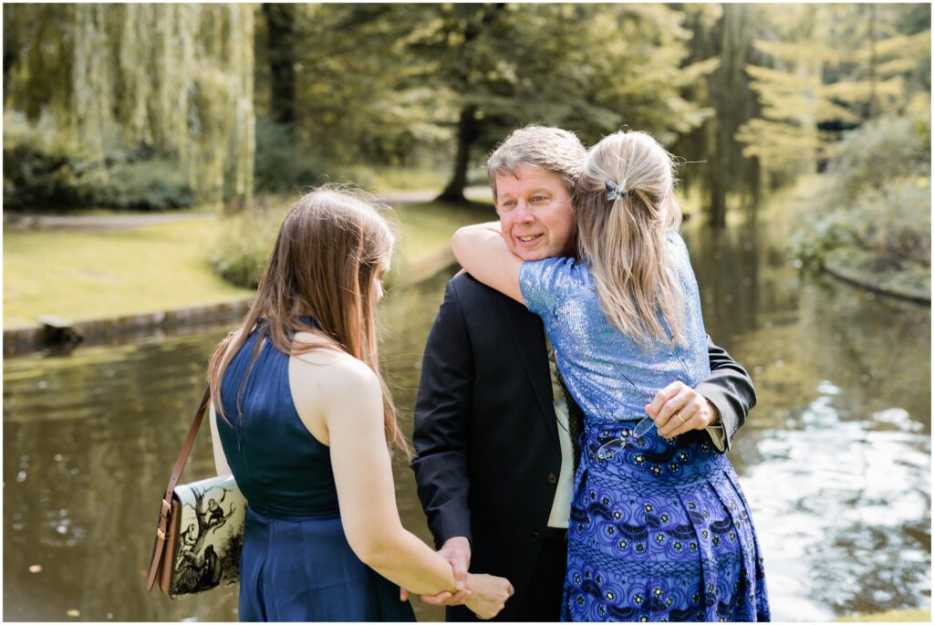 Sisters hold and hug their dad in Copenhagen after the wedding ceremony.