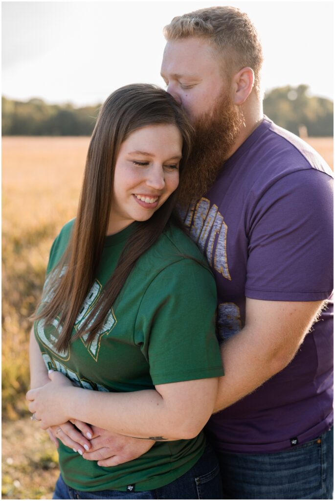Couple hugging with Green Bay Packers and Minnesota Viking shirts. 