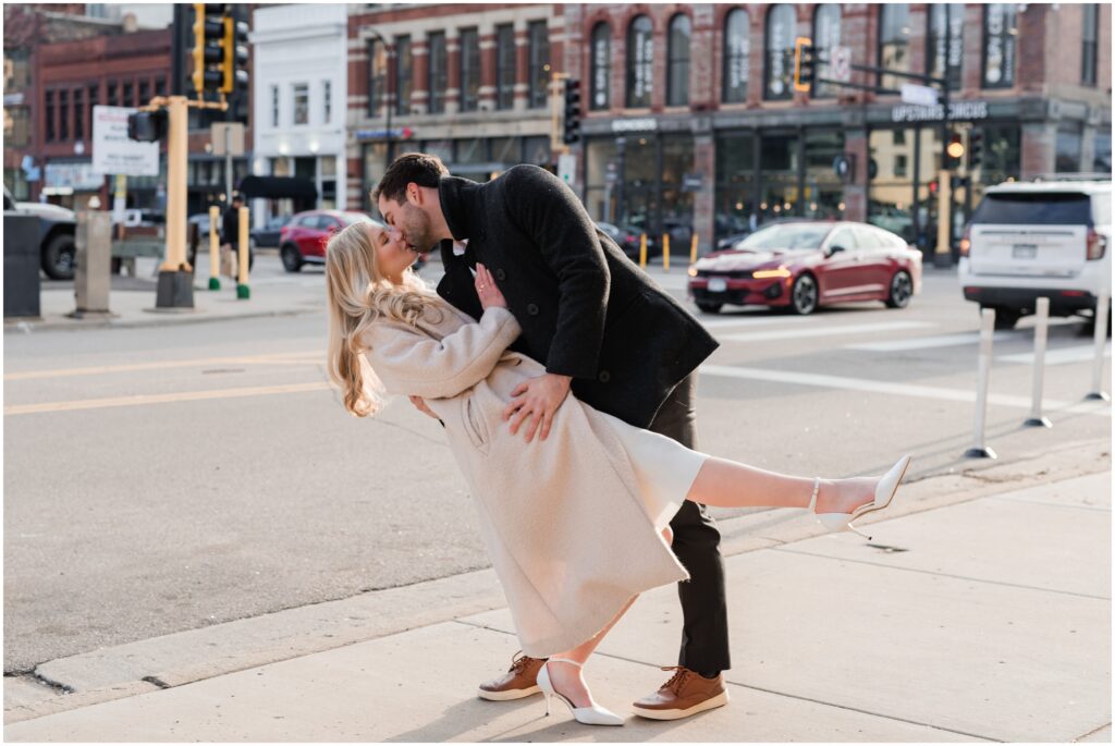 An engaged couple dip kiss in the North Loop of Minneapolis.