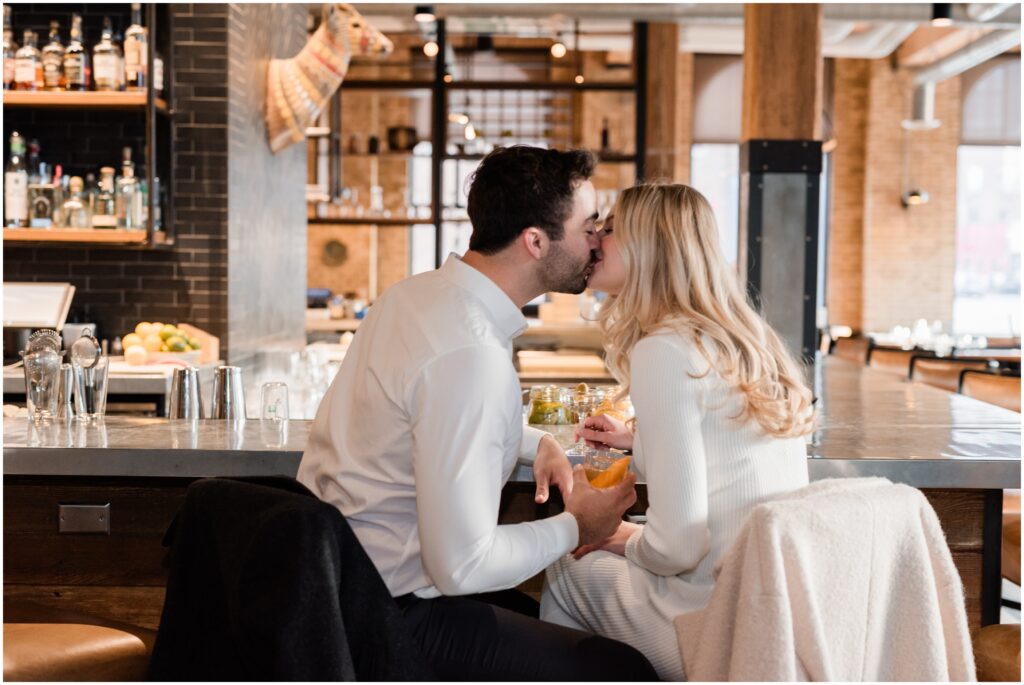A couple kisses in the restaurant of Hewing Hotel. 