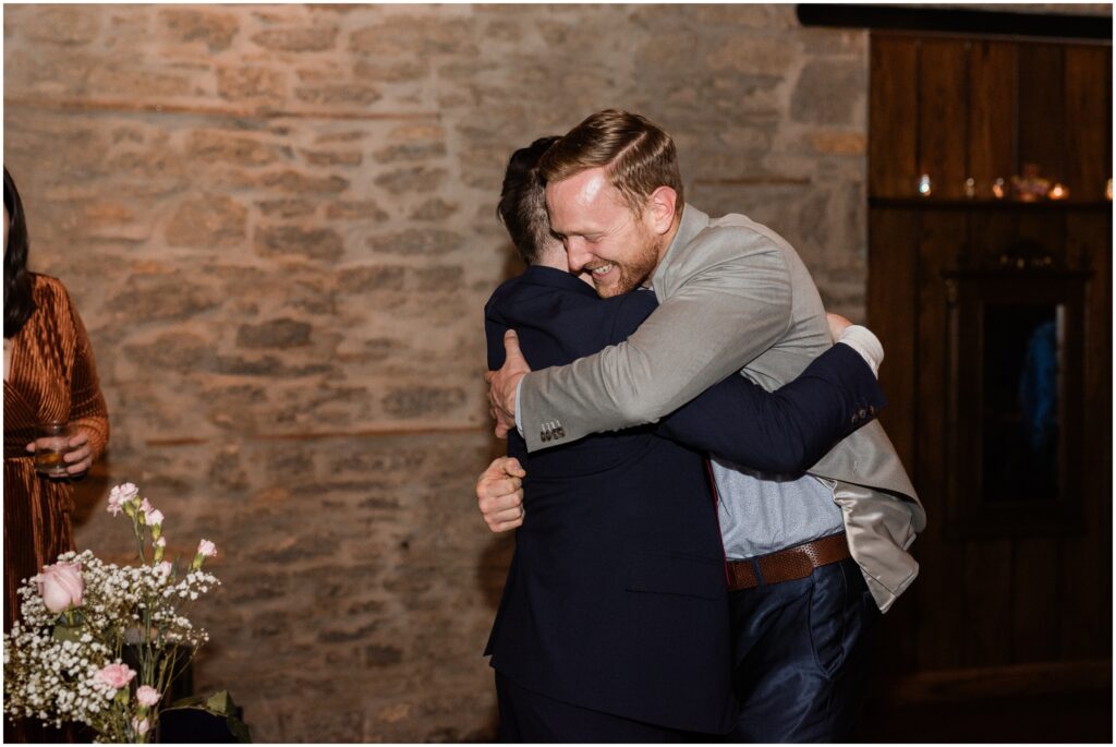 The groom hugging a friend at Aster Cafe.